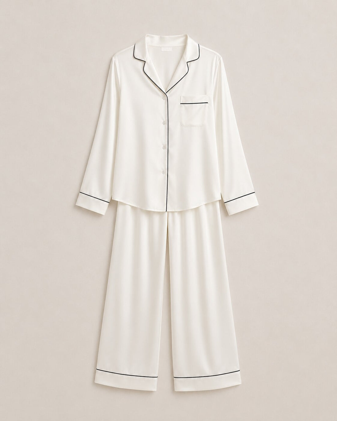 Cream silk pajamas laid flat, showing the soft lustre of well-cared-for silk